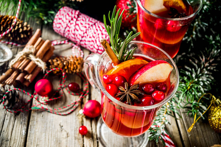 传统的圣诞覆盖葡萄酒，grog或热辣桑格里亚鸡尾酒在古老的乡村木桌上，圣诞装饰和杉树枝复制空间顶部视图。