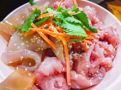 涮猪肉套美味的涮生猪肉鱿鱼和白芝麻在肉上，胡萝卜和香菜放在涮锅上煮
