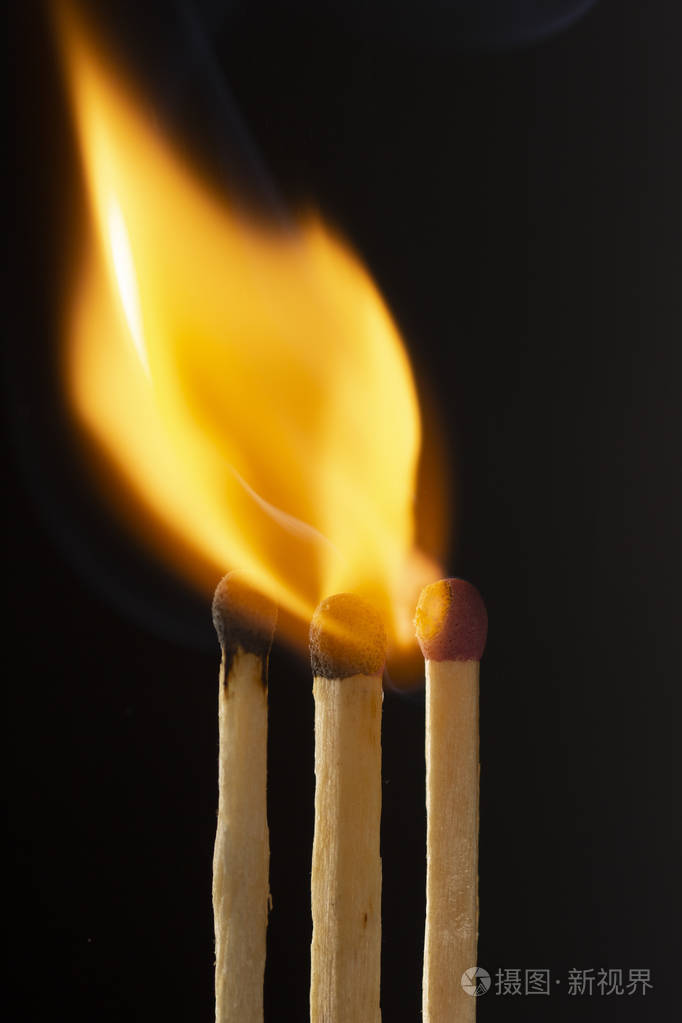 燃烧的木制火柴黑色背景上有一个红色的火柴头近点