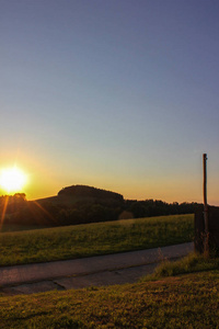 德国南部的日落黄昏，地平线上有树木和绿草地草地景观