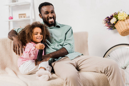 非裔美国人男人和女儿在客厅看电视