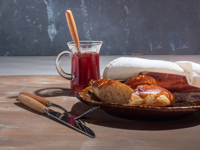 玻璃壶餐具中装饰盘子糖浆上的小面包，棕色背景上的棉巾