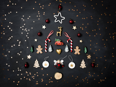圣诞树形状的圣诞装饰和姜饼饼干在黑暗背景新年概念