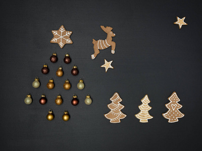 圣诞树形状的圣诞装饰和姜饼饼干在黑暗背景新年概念