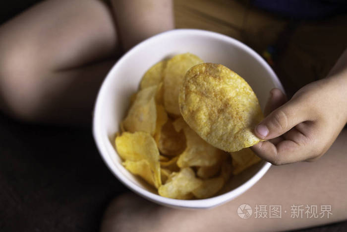 儿童手拿薯片接近有害食品的概念快餐