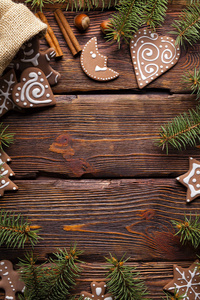 木制背景的姜饼圣诞饼干和云杉树