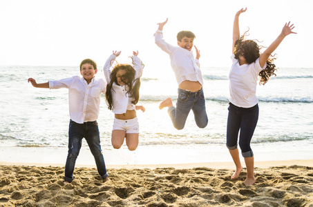 快乐的孩子们一起在海滩上跳跃