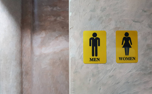 男女公厕。 女士和绅士洗手间的标志叫WC。 混合性别符号厕所和厕所后面的混凝土墙装饰复古风格在百货公司。 短信
