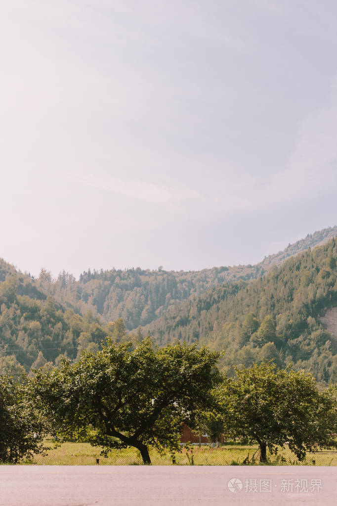 夏天阳光明媚的山景路和路边的旅游巴士