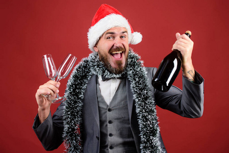 企业圣诞晚会让我们喝香槟吧。老板圣诞老人帽子金丝庆祝新年或圣诞节。圣诞派对请柬男人留着欢快的嬉皮士圣诞老人拿着瓶子。庆祝圣诞节