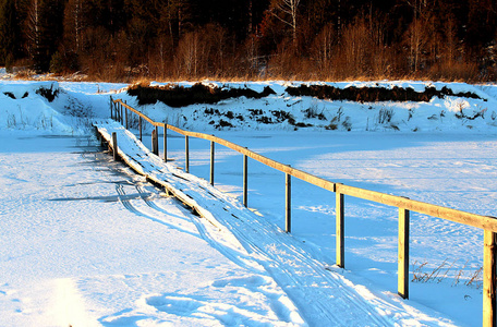 冰冻河流上的冬季木桥