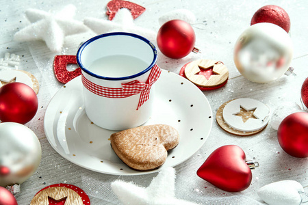 圣诞装饰与牛奶盘姜饼雪花和小泡在白色桌子上
