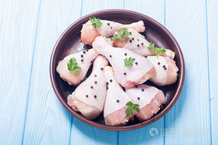 生鸡腿加香料和欧芹。 食物背景