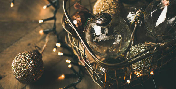 圣诞节或新年背景。 老式圣诞树金色玩具装饰球在盒子和轻装饰球在乡村木桌背景选择焦点