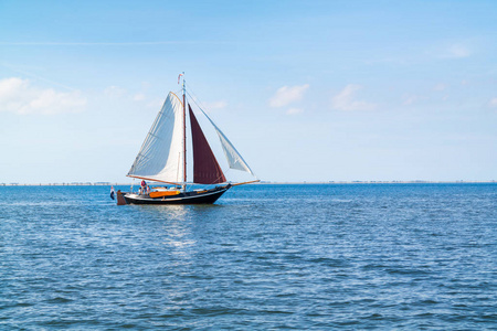 在荷兰特塞尔岛附近的瓦登西航行的平底帆船上的人们照片