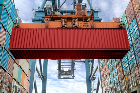 工业起重机装载集装箱在货运船上。 集装箱船在进出口业务物流公司。 工业和运输概念。