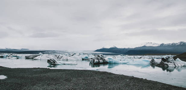 巨大的冰块从冰岛海滩海岸的冰山上分离出来。