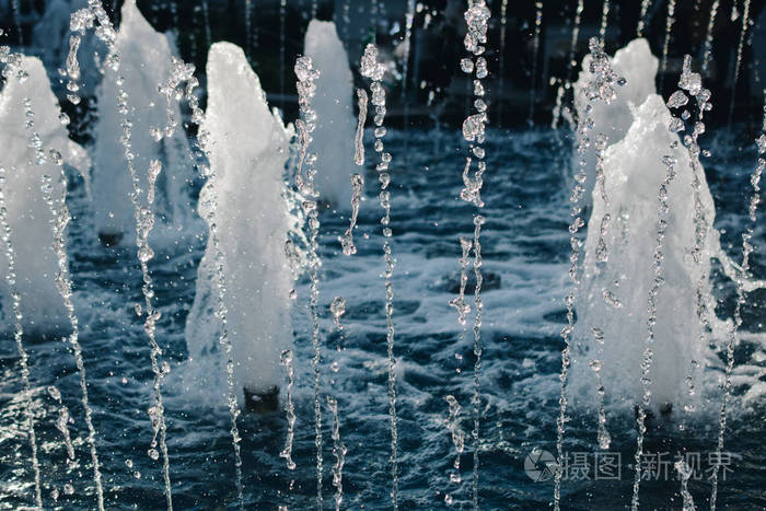 喷泉在公园的水池里涌出闪闪发光的水