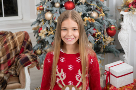 送圣诞礼物。新年快乐。快乐的小女孩庆祝寒假。圣诞节时间。可爱的小女孩与圣诞节礼物。利用圣诞节销售的优势。最喜欢的毛衣