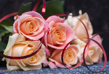 喜庆的玫瑰花在桌面上用丝带轻轻地涂上奶油色