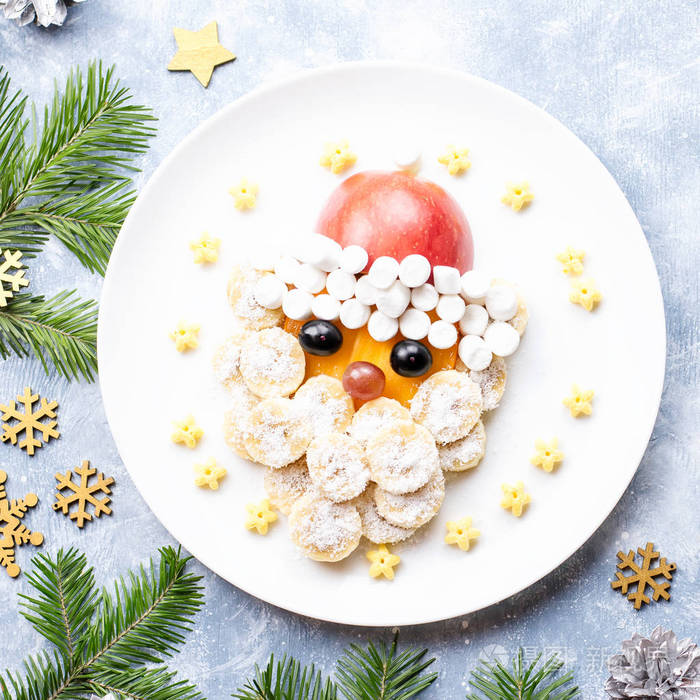 圣诞老人的脸是由水果和棉花糖制成的放在盘子里儿童圣诞食品