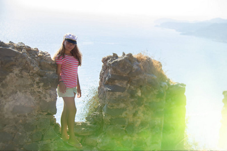 海背景和石墙背景上女孩的剪影。