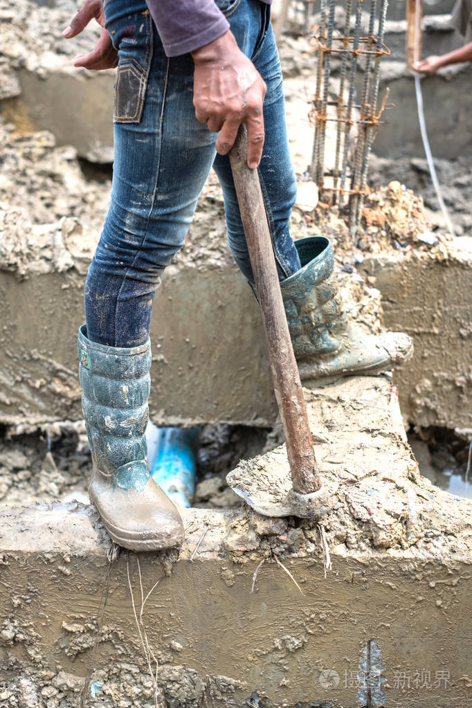 一个男人拿着铲子在新房子建筑工地上