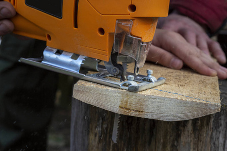 人类在户外使用电锯切割木材产品。 近点