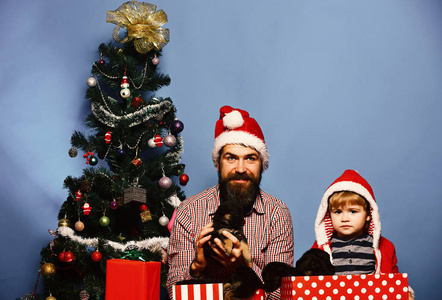 爸爸带着胡子和孩子在圣诞树旁抱着狗