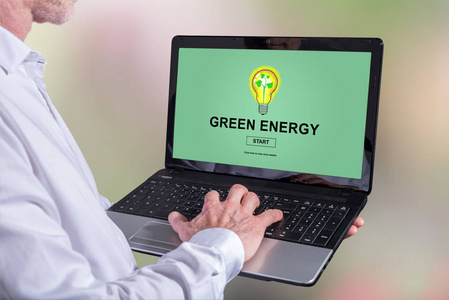 在屏幕上使用绿色能源概念笔记本电脑的人