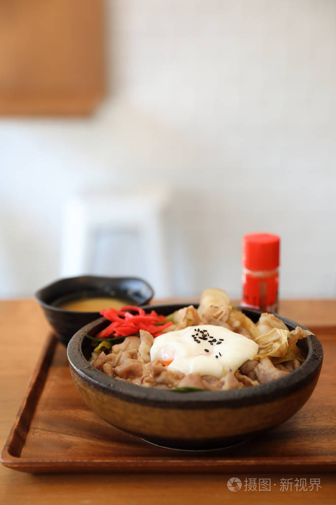 日本菜吉顿日本牛肉放在饭碗上,木桌上放着鸡蛋