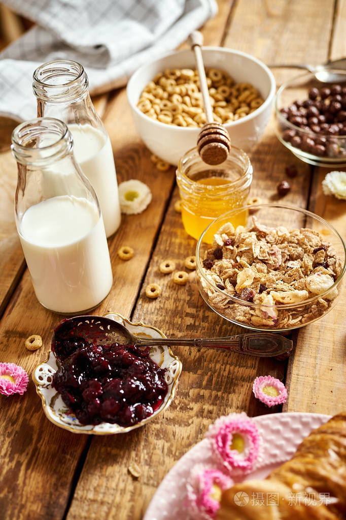 健康早餐配不同类型的早餐麦片含蜂蜜果酱羊角面包和牛奶