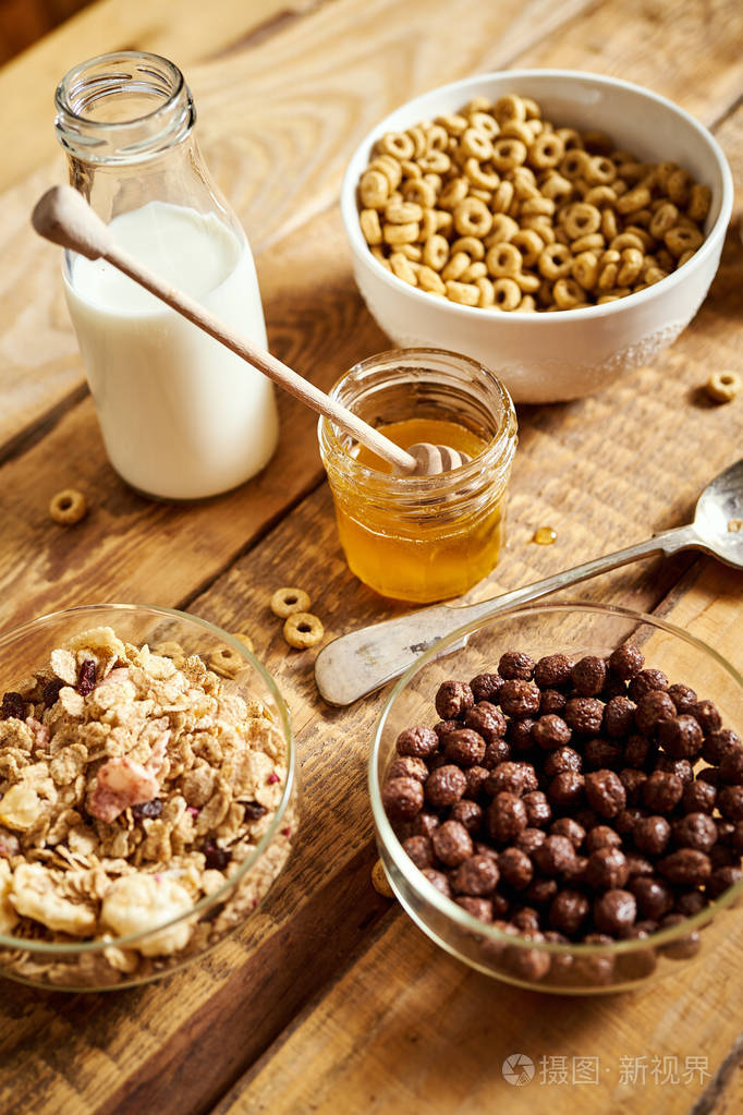健康的早餐包括不同类型的早餐麦片桌上有蜂蜜和牛奶
