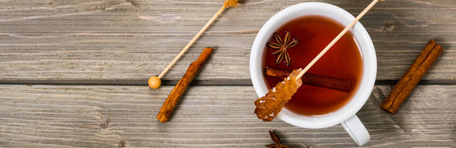 一杯热辣茶与肉桂八角和蜂蜜在木制背景顶部视图。 全景图像。 选择性聚焦。