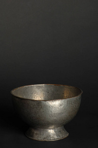 黑暗背景上的古代金属碗。 古董青铜器