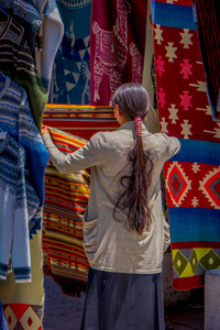 土著妇女穿着安迪亚法传统服装并在奥塔瓦洛市街头市场销售一些产品的背景