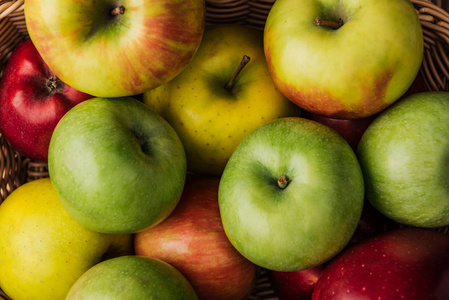 在柳条篮子里，近距离观看成熟的五彩苹果