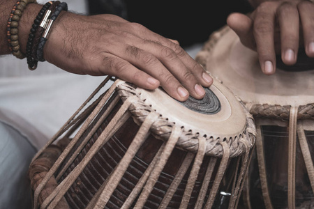 s hands wearing beads playing the Tabla  Indian classical mus