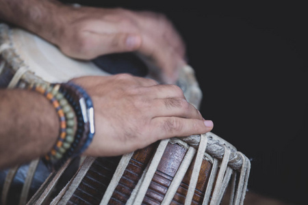 s hands wearing beads playing the Tabla  Indian classical mus