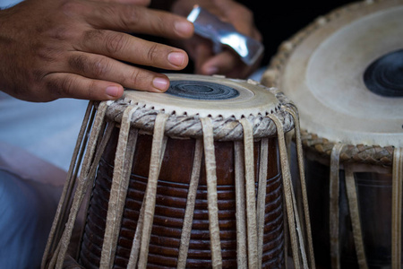 s hands wearing beads playing the Tabla  Indian classical mus