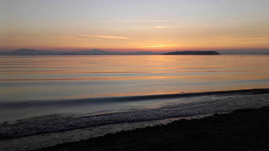 意大利翁布里亚，日落时的特拉西门诺湖景观，背景是伊索拉马吉奥尔