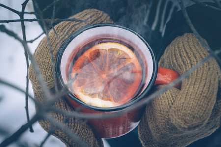 s hands mittens. Hot winter drink outdoor in snowy winter forest