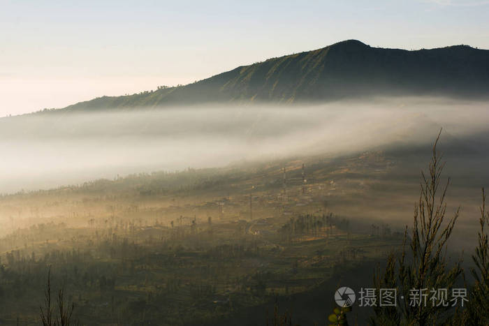 布朗莫火山旁边的村庄，日出时，背景塞莫罗朗村在布罗莫登格谢默鲁国家公园东爪哇印度尼西亚。