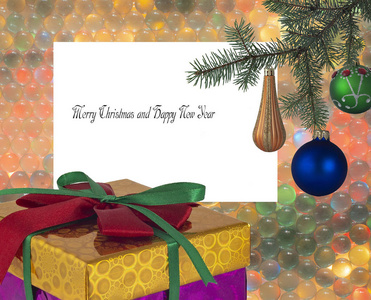 圣诞贺卡上的圣诞祝福语是一个带有绿色和猩红色蝴蝶结和圣诞树上的玩具的礼品盒