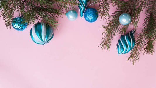 圣诞快乐，新年快乐。 圣诞卡节日与绿色冷杉枝和节日对象的粉红色背景。