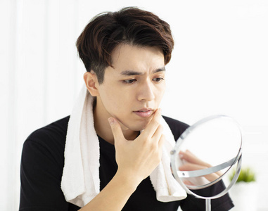 年轻爱的情侣在刷牙时照镜子男人用洗面奶洗脸香皂在家里浴室照镜子