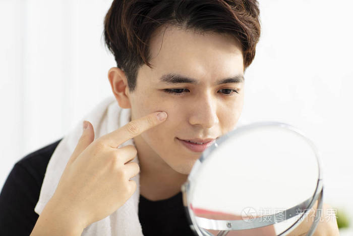 英俊的年轻人照镜子