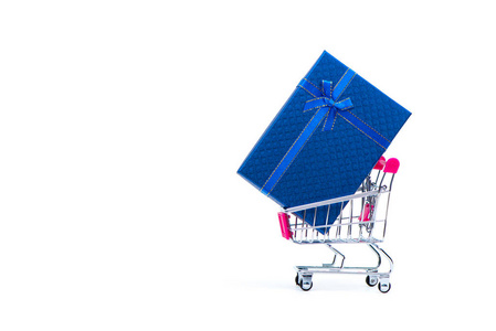 蓝色礼品盒带蝴蝶结和购物车或超市手推车隔离在白色背景上，复制空间为季节或问候和愉快的概念在假期。