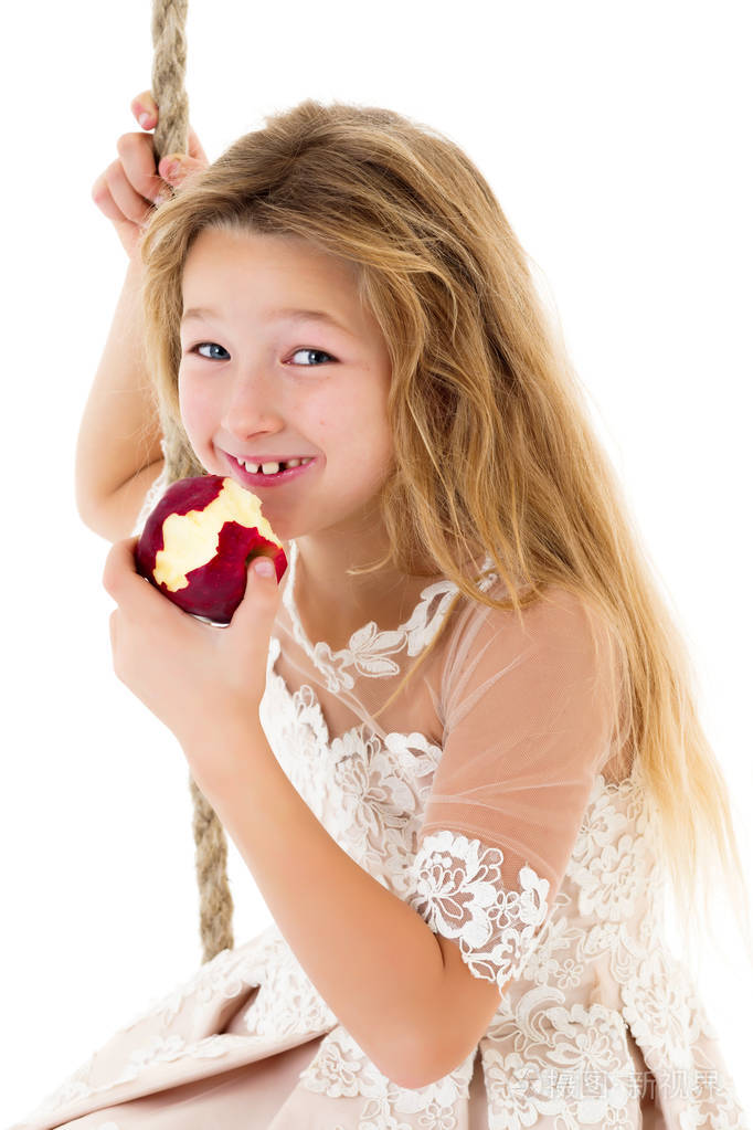 在秋千上吃苹果的小女孩