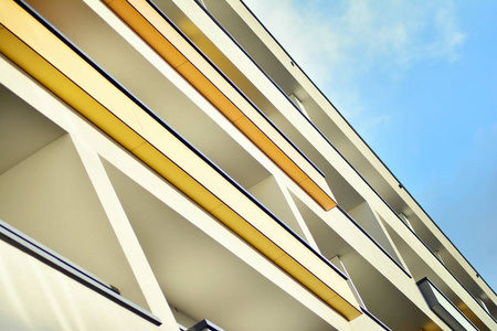 现代公寓楼在阳光明媚的日子里有一片蓝天。 现代公寓楼的正面